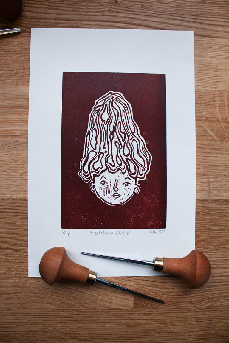 linoleumprent in donkerbruin van paddenstoelenhoofdje op papier. met linogutsen