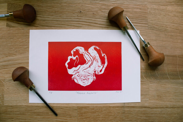 linoleumprent in gradiënt oranje-rood van paddenstoelenhoofdje op papier. met linogutsen