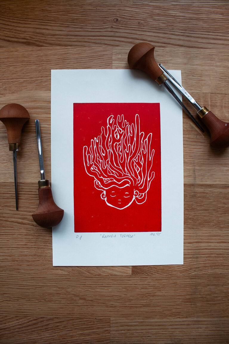 linoleumprent in oranje-rood van paddenstoelenhoofdje op papier. met linogutsen