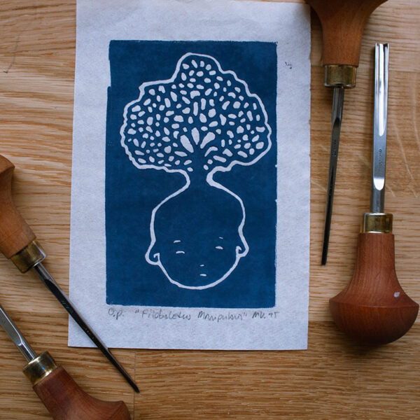 linoleumprent in donkerblauw van paddenstoelenhoofdje op papier. met linogutsen