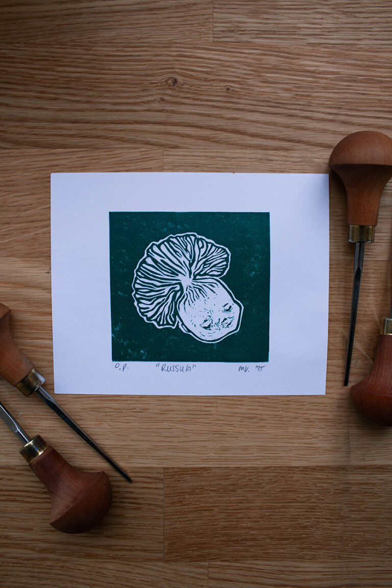 linoleumprent in donkergroen van paddenstoelenhoofdje, op papier. met linogutsen